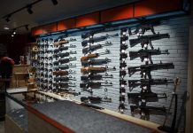 Wall display of various rifles in a gun store.