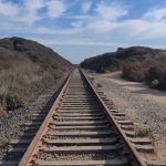 Railway tracks stretching into the distance, surrounded by vegetation.