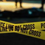 Police tape marking a crime scene at night.