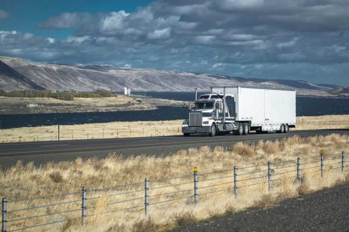 Truck driving on rural highway near river and mountains