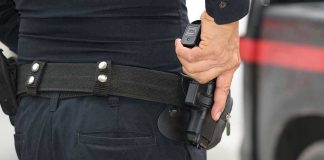 Person holding a gun in a holster.