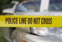 Yellow police tape in front of a car.