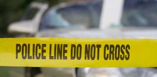 Yellow police tape in front of a car.