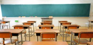 Teacher FIRED Over Poster—Federal Lawsuit Explodes Empty classroom with desks and a chalkboard.