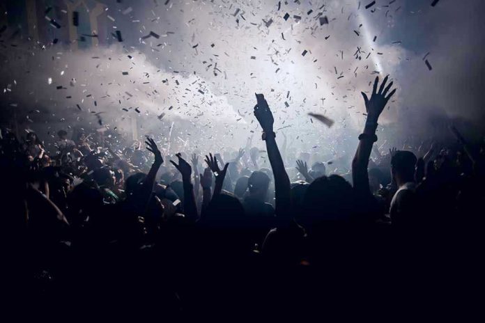 420455902 Crowd celebrating under confetti and bright lights.