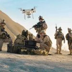 Combat Assets Hijacked—To Save Abandoned Animals Soldiers operating a drone in a desert environment.
