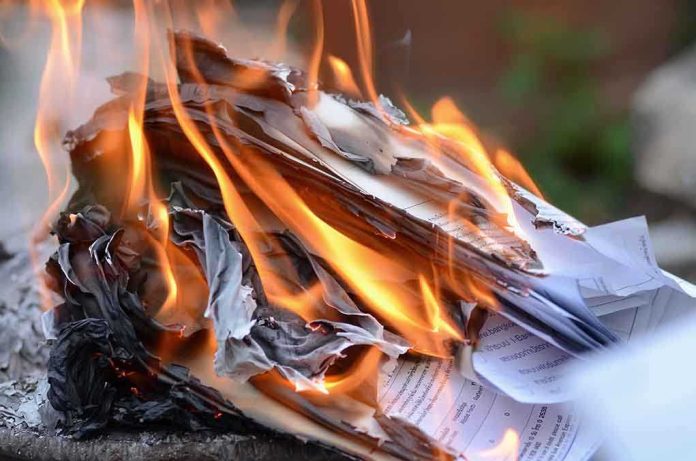 Burning papers with flames and smoke rising