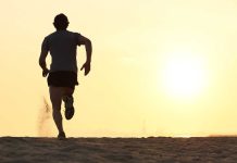 Silhouette of a man running on the beach during sunset