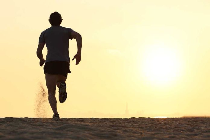 Silhouette of a man running on the beach during sunset