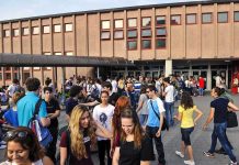 A large group of students socializing outside a school building