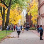 ChatGPT Helped Shooter Plot Campus Massacre Students walking on a campus path surrounded by autumn trees and brick buildings