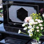 SICKENING Vile Trend Targets Metcalf’s Grave! Colorful flowers on a black tombstone.