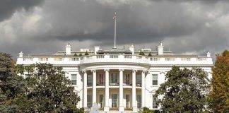 The White House with overcast sky and flag raised.