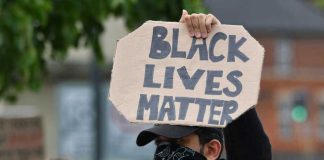 BLM Leader Issues Most RACIST Statement Yet! Person holding Black Lives Matter sign at protest.