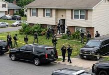 Law enforcement officers conducting a raid in a residential neighborhood