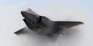 Stealth fighter jet piercing a vapor cloud