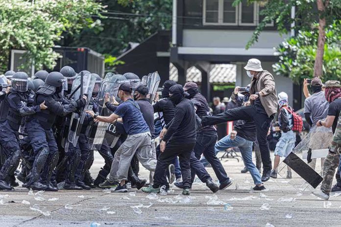 shutterstock_1816967924 Protesters clash with riot police holding shields