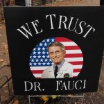 Fauci Action Figure Haunts Texas Democrat yard sign with portrait of a doctor over a U.S. flag
