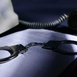 Epstein’s Top Fixer Found Dead – Questions Explode Handcuffs on a document beside a coiled telephone handset