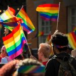 Dem Candidate Creep Campaigned With 11 YEAR-OLD Drag Queen Crowd waving rainbow flags at an outdoor event
