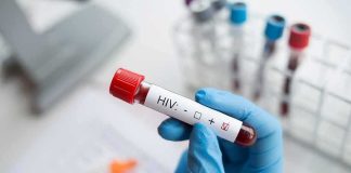 Controversial AIDS-Era Ban Coming Back Gloved hand holding a blood sample tube labeled for HIV test