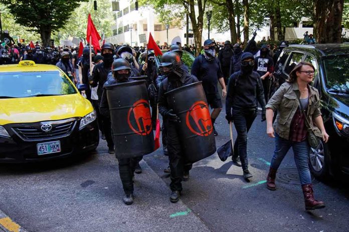masked protesters march with shields on a city street