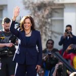 woman in navy suit waving at outdoor event