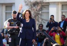 woman in navy suit waving at outdoor event