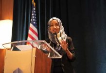 Woman in hijab speaking at a podium