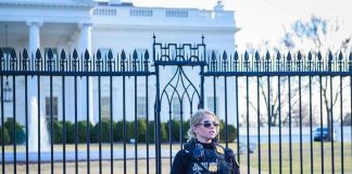 Security officer stands guard outside a large white government building