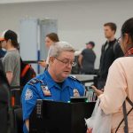 tsa officer checks a traveler's documents at airport security