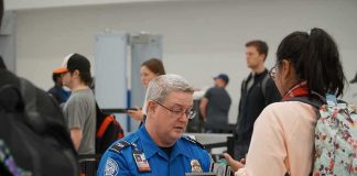 tsa officer checks a traveler's documents at airport security