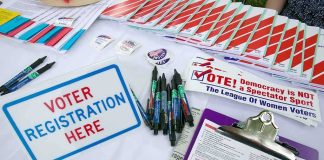 Dems Push to LOWER Voting Age Voter registration table with forms, pens, and informational materials