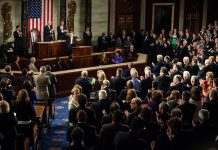 Legislators give a standing ovation in a grand chamber