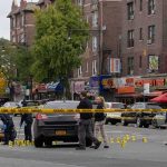 Police investigate a taped-off urban street crime scene