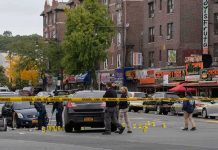 Police investigate a taped-off urban street crime scene