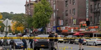 Police investigate a taped-off urban street crime scene