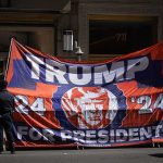 Trump’s Mega-Store BANKRUPT — Immediately Closes Large political banner at street protest with police nearby