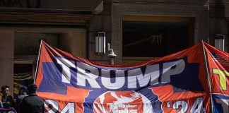 Large political banner at street protest with police nearby