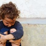 Child Daycare Fight Club Allegation Shocks Town child sitting on ground with arms wrapped around knees