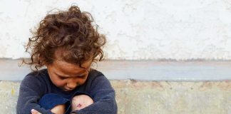 Child Daycare Fight Club Allegation Shocks Town child sitting on ground with arms wrapped around knees