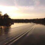 Trump Signs EO Renaming Great Lake Boat wake curving across a calm lake at sunset