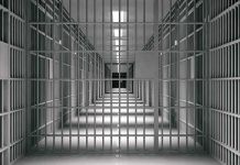 empty prison corridor with barred cells