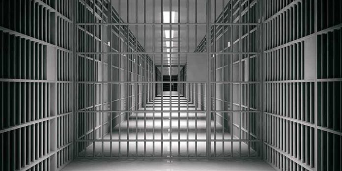 empty prison corridor with barred cells