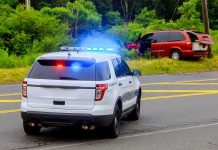 Police SUV with flashing lights at roadside crash scene