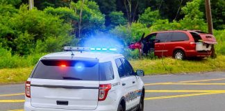 Police SUV with flashing lights at roadside crash scene