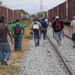 Deadly Boxcar Horror in Texas Heat Group of people walking along railroad tracks between freight trains