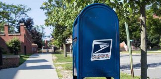 Blue USPS mailbox on a suburban sidewalk