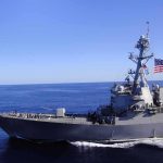 Marines Storm 12 Commercial Vessels – Why! Naval destroyer sailing on open sea with flag flying