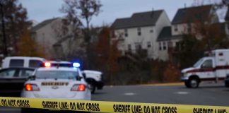 Sheriff's vehicles behind yellow do-not-cross tape